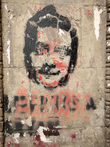 Protest graffiti on old grey stone posts that line the Paseo de la Reforma in Mexico City
