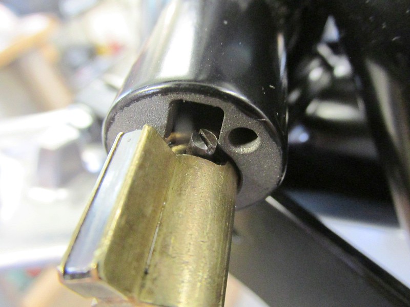Install Fork Lock Tumbler By Catching Screw Head On Edge Of Lock Housing