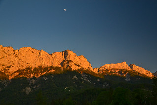 The moon above the sunset-lit mountain walls