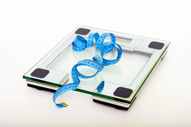 blue-tape-measuring-on-clear-glass-square-weighing-scale-53404