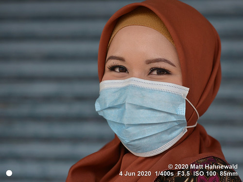 matthahnewaldphotography facingtheworld qualityphoto head shoulders face eyes expression lookingatcamera headscarf brown hijab facecovering disposable surgical mask consensual ethnicity diversity humanity beauty health safety style virtue corona virus covid19 pandemic epidemic outbreak newnormal traditional cultural muslimah islam islamic clothing kuah langkawi malaysia asia asian malay adult person one female young woman women detail primelens nikond610 nikkorafs85mmf18g 85mm street appearance portrait closeup headshot threequarterview sidewaysglance outdoor colour color posing beautiful elegant copyspace clarity surgicalmask greatreset sharpness