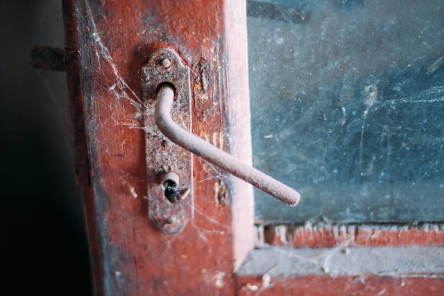 Vintage door handle covered with cobweb