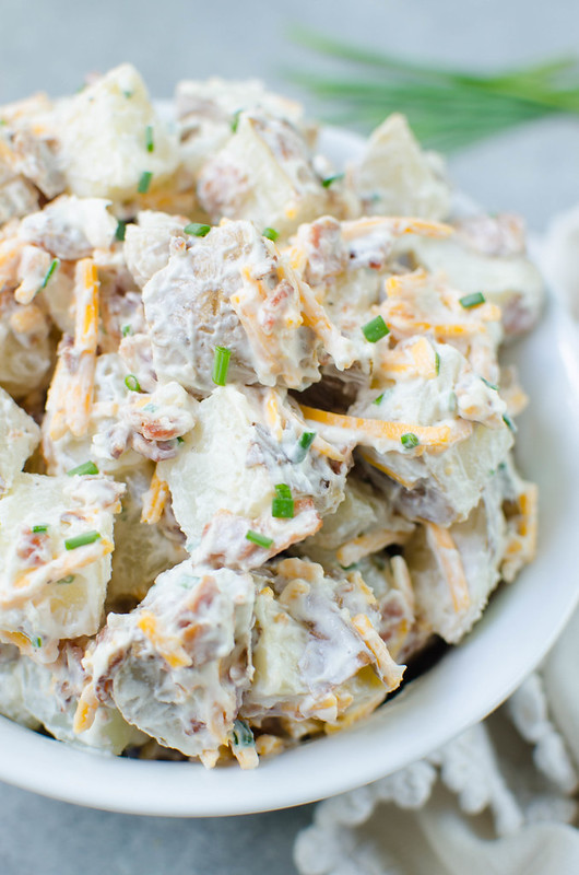 Baked Potato Salad - everything you love about baked potatoes in a potato salad! Potatoes tossed in sour cream, bacon, cheddar cheese, and chives. Perfect for summer barbecues!