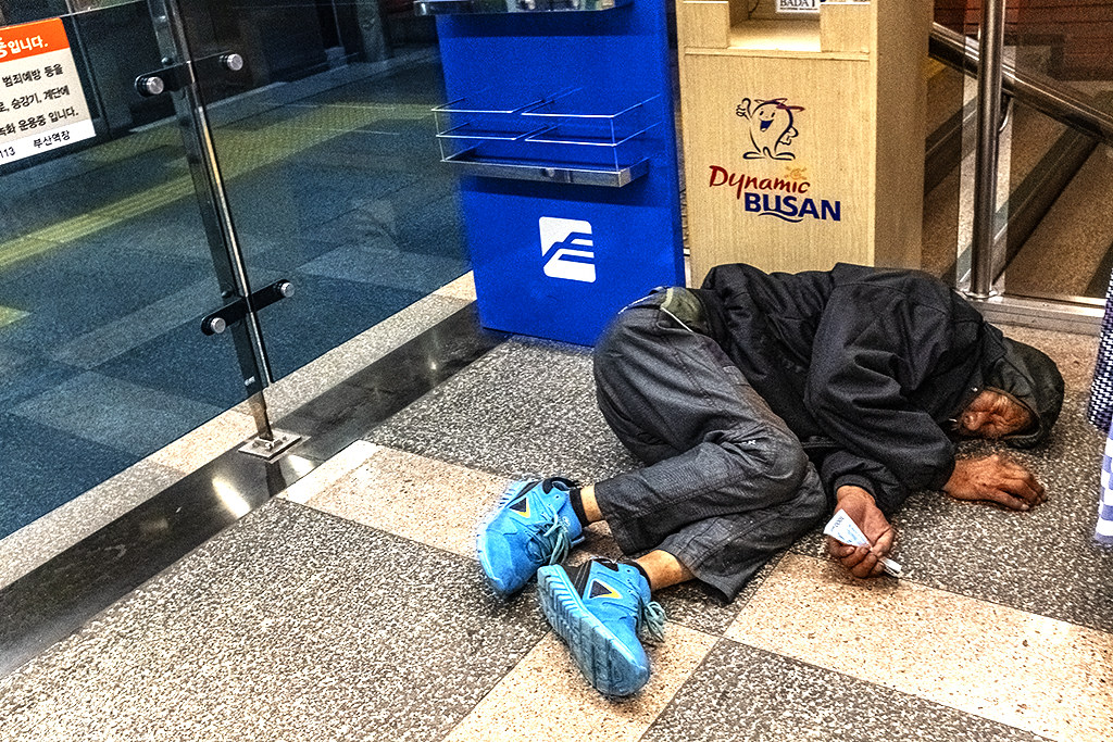 By subway entrance at Busan Station on 6-12-20, an old man lying on the ground, clutching money--Busan