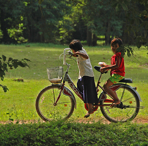 kids getting around on a too big bike at Angkor Wat in Cambodia