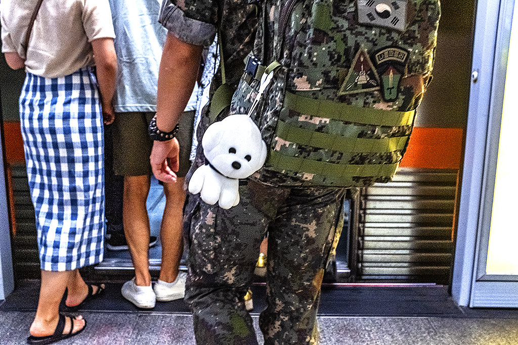 Toy dog swinging from soldier's backpack at Seomyeon Station in Bujeon-dong--Busan
