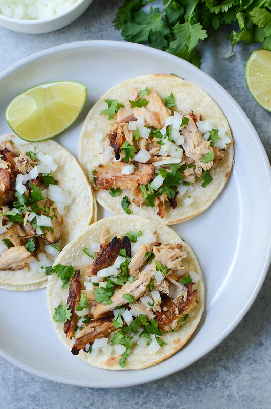 Slow Cooker Carnitas Street Tacos - like from your favorite taco truck! Pork carnitas cooked in the crockpot and piled on corn tortillas with diced onion and cilantro. 