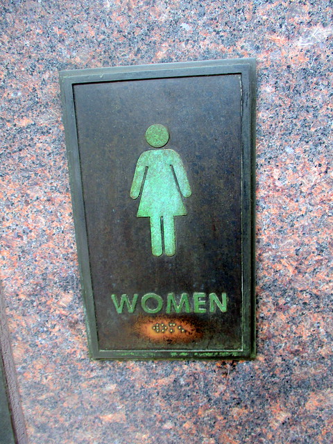 Sign for Women’s Restroom in Entrance to Restrooms in North Façade of Information and Bookstore from North