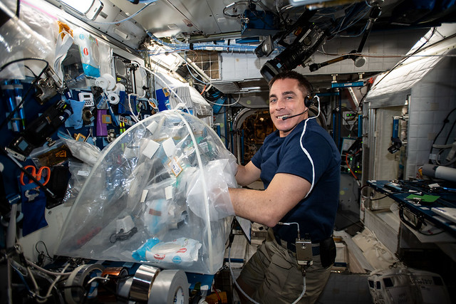 NASA astronaut Chris Cassidy services biological samples in a glovebag