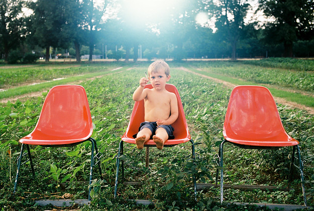 Three Red Chairs and a Boy
