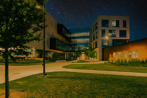 night nightphotography nightscape kansasuniversity ku universityofkansas schoolofbusiness structure building landscapelighting grass stars blue glass reflection