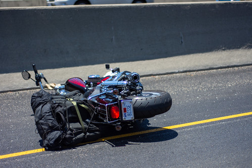 Camarillo, California / USA -  July 2, 2020: A mortorcycle lies on its side after a collision by a downed motorcyclist in the Conejo Pass, Northbound lane.  The motorcyclist was injured and required emergency services from public safety officials and para | by GlennHighcove