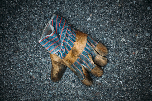 Dirty worker glove left on the ground at a construction site