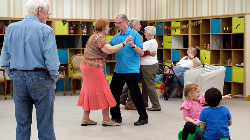 A group of people of mixed ages dancing and playing