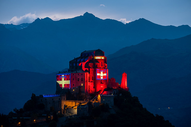 The Sacra di San Michele illuminated by the Piedmont flag for the 50 years of the Region, Italy.