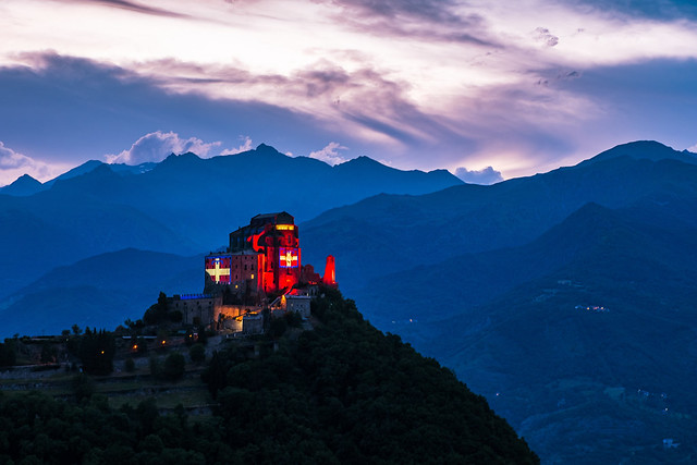 The Sacra di San Michele in the evening illuminated by the Piedmont flag for the 50 years of the Region.