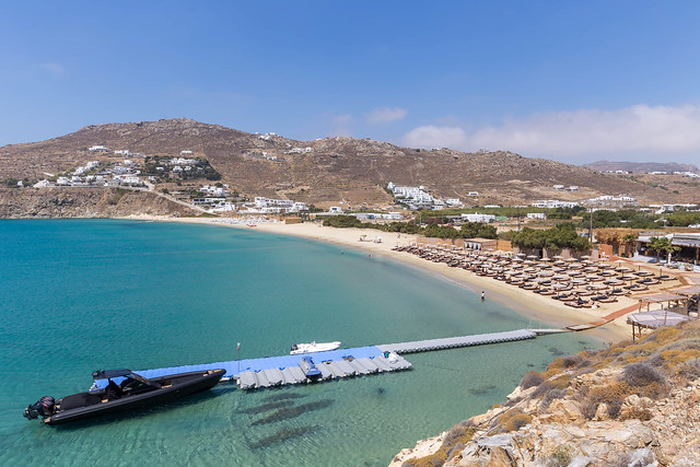 Kalo Livadi Strand auf Mykonos (Griechenland) mit kleiner Seebrücke und schwarzem Motorboot