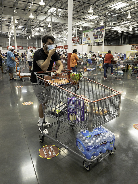 Image of a late 20s-early 30-something year old man named Rafael at Costco at the checkout line, wearing a face mask in Orlando, Florida on August 7, 2020.