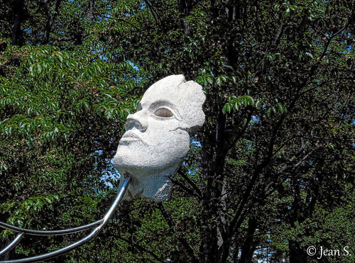 statue mask trees art green white park