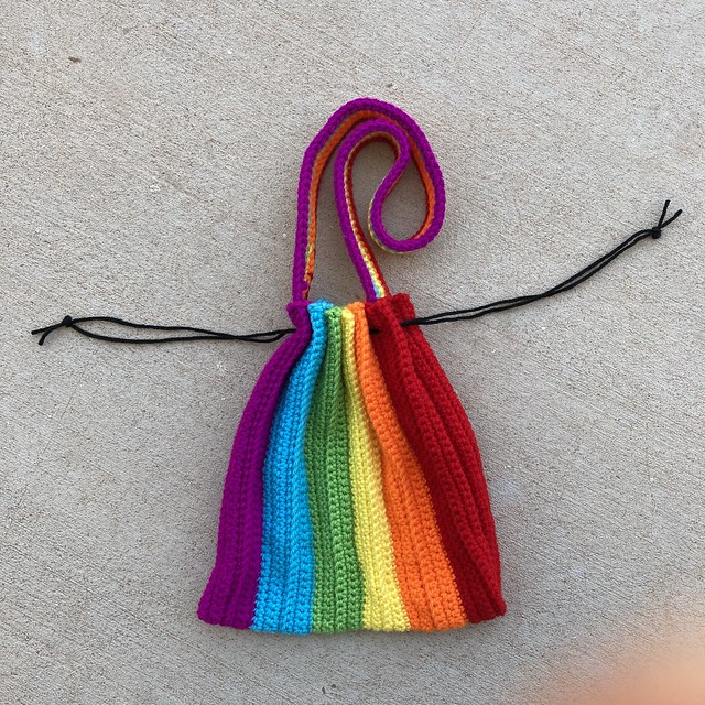 A rainbow drawstring crochet purse ready for adventure