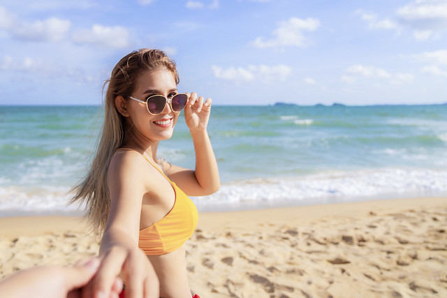 Asian woman relax on the beach with her couple in holiday trip