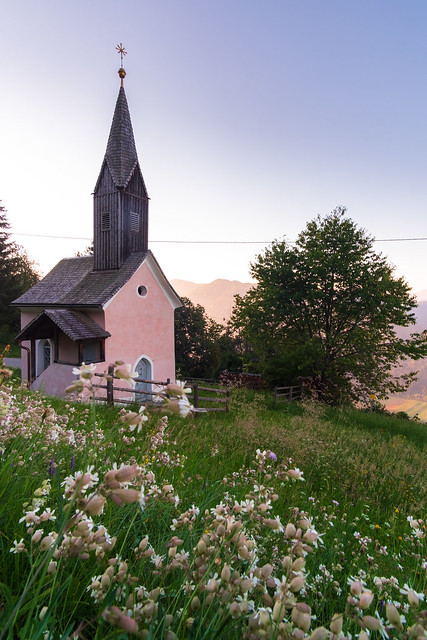 Cute pink church just after sunrise high on the steep mountains of the Drau valley