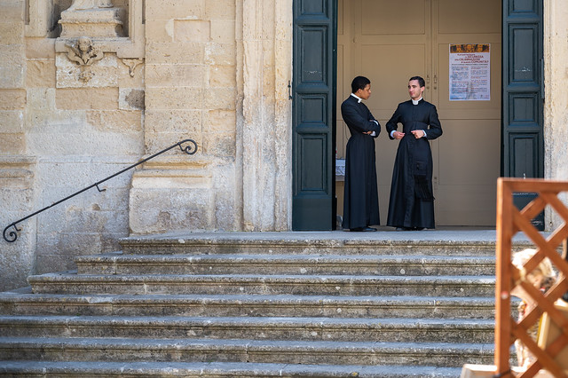 2 young and handsome priests well aware that women and men turn around to look at them