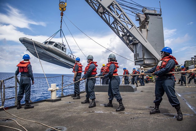 Deck department Sailors lower a rigid-hull inflatable boat from the amphibious dock landing ship USS Germantown (LSD 42) for a visit, board, search and seizure (VBSS) exercise.