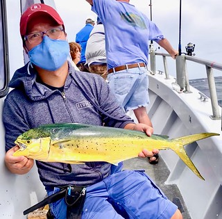Photo of man holding a small dolphinfish