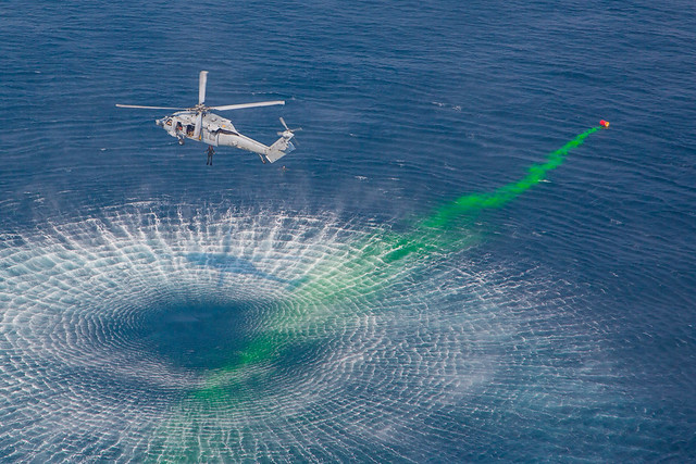 An MH-60 Sea Hawk helicopter prepares a detonation site during a mine countermeasures interoperability exercise in the Arabian Gulf.