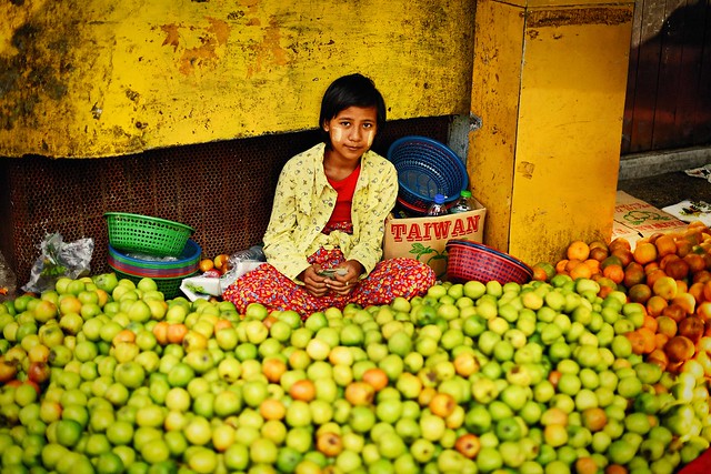 A young girl selling apples on the street