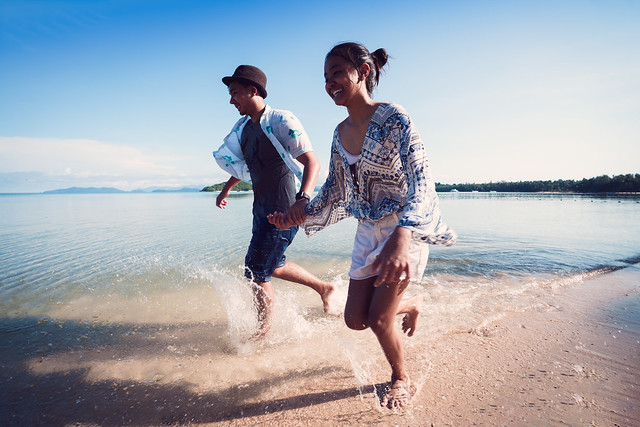Asian teenage girl and boy running on the beach