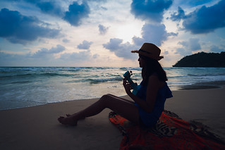 Teenage girl playing ukulele on beach