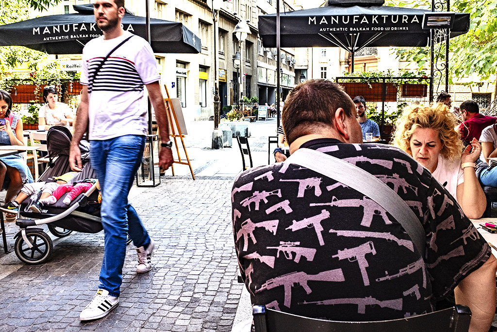 Man with guns on shirt at Manufaktura Restaurant--Belgrade