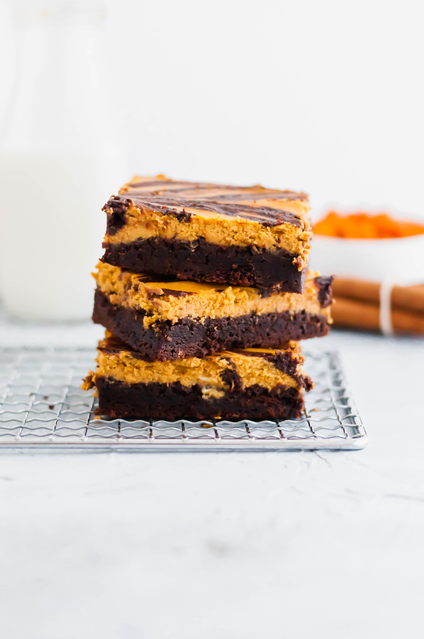 These Pumpkin Cheesecake Brownies are a must try dessert this fall. Thick, fudgy one pot brownies topped with a simple, delicious spiced pumpkin cheesecake. Fall perfection.