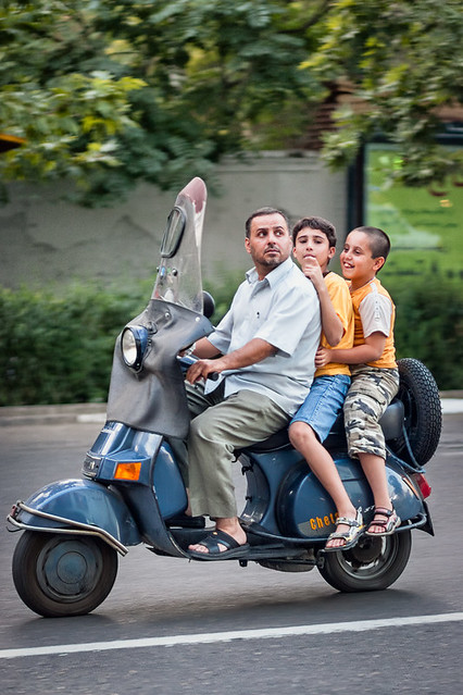 Iranian man and two boys on moped in Tehran