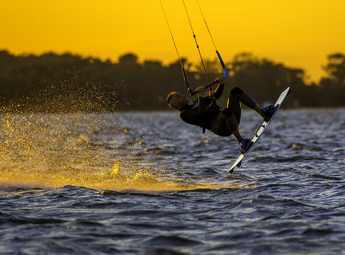 Photo of kiteboarder on the water at sunset