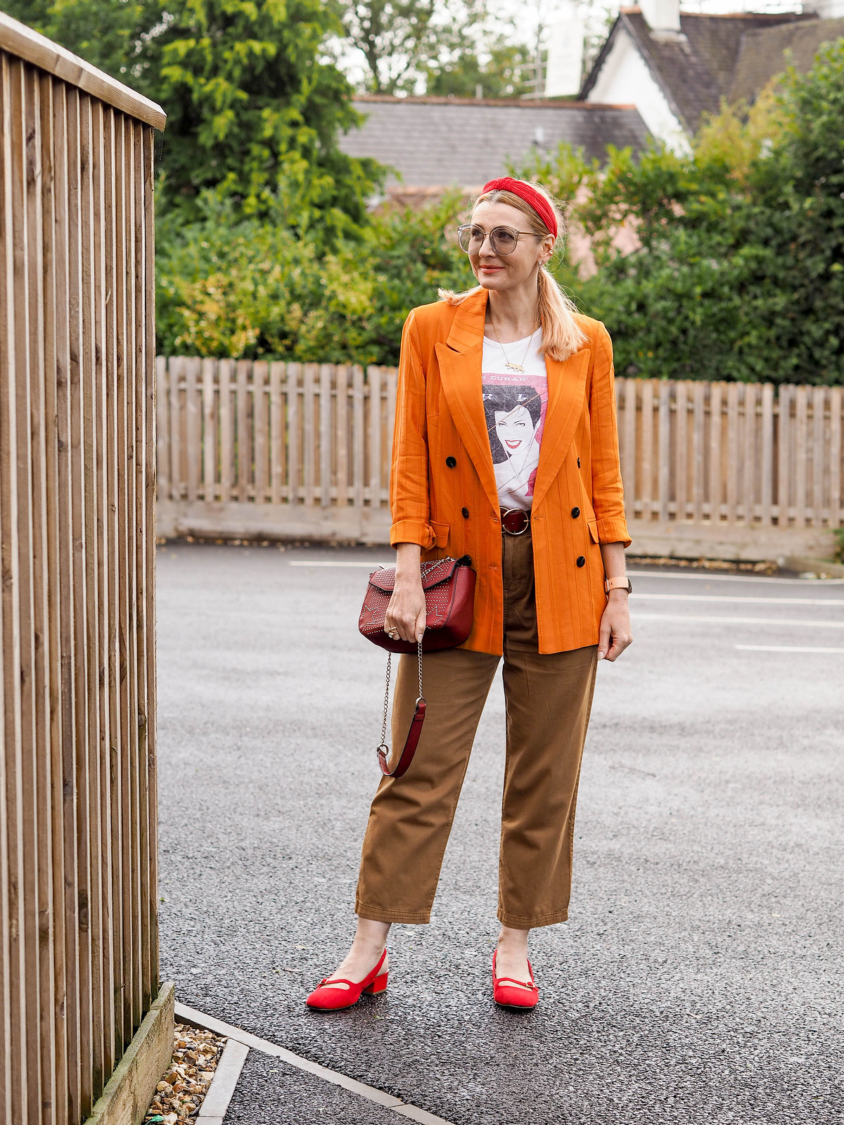 The Power of Accessories: A Blazer, T-shirt and Trousers Story (Catherine is wearing an orange blazer, brown relax fit trousers, a Duran Duran Rio album print t-shirt, red slingback shoes and red accessories) | Not Dressed As Lamb, over 40 style