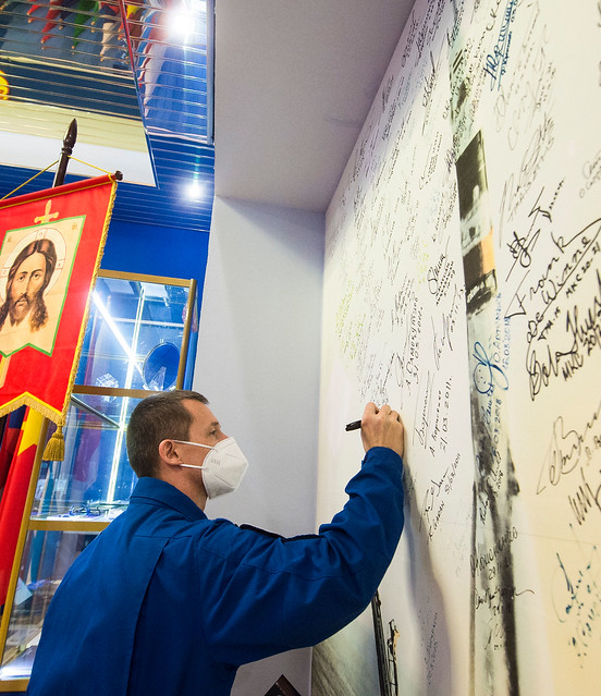 Cosmonaut Sergey Ryzhikov signs a wall mural