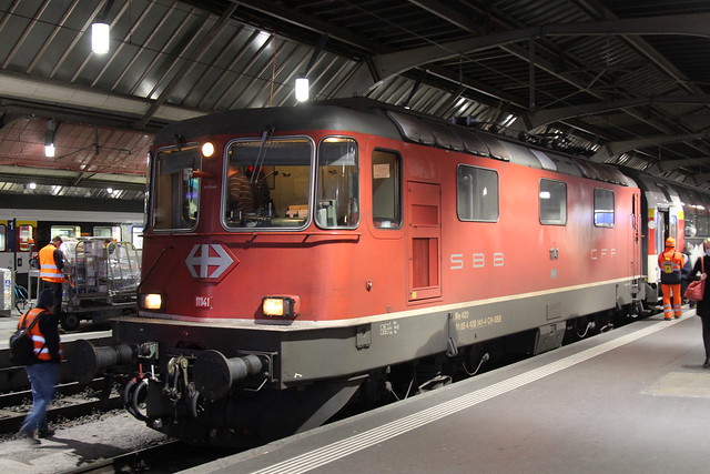 SBB Lokomotive Re 4/4 II 11141 bzw. 420 141 - 4 in rot mit dem Swiss - Express Signet ( Hersteller SLM Nr. 4673 - BBC MFO SAAS - Baujahr 1967 )  am Bahnhof Zürich HB im Kanton Zürich der Schweiz