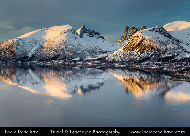 Norway - Senja island - Bergsfjorden and its surrounding mountains under fresh cover of snow during winter time at Sunset