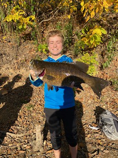 Photo of young man holding smallmouth bass