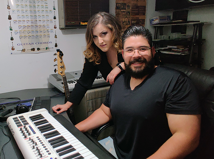 Joel and Candace Vargas sit in front of a keyboard.