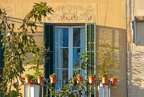 wall shadow facade sitges shutter pots plants balcony cherub window curtain