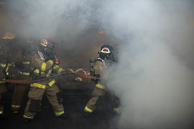 A hose team attacks a mock fire during a firefighting drill aboard USS New Orleans (LPD 18).