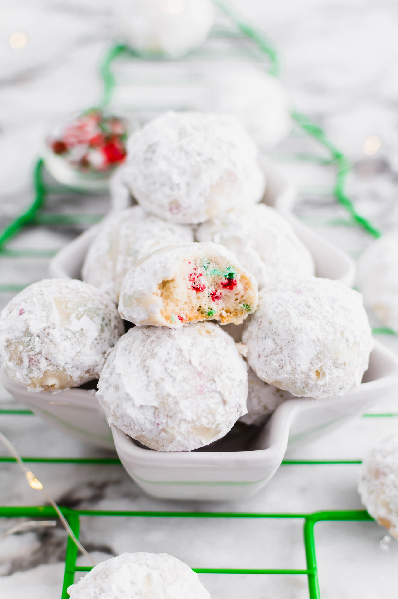 Tender, melt in your mouth Christmas Snowball Cookies are the perfect addition to your baking list this season. Super festive and fun.