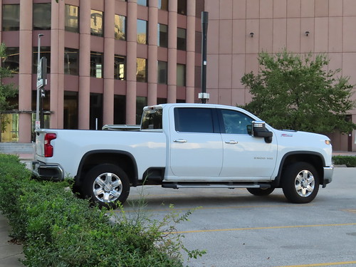 White Chevy Silverado 1500 side view while parked in city parking lot