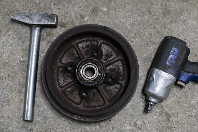 Close-up of a drum brake between a hammer and an air impact wrench