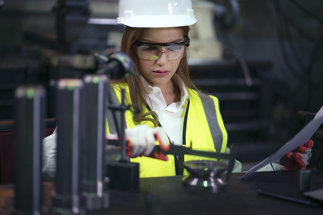 Female factory worker inspecting production line