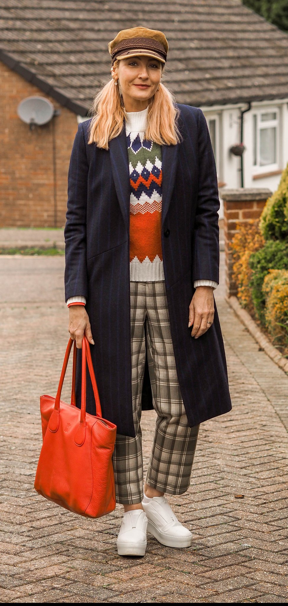 Styling a Classic Tailored Coat With Bold Winter Patterns (navy pinstripe coat, orange, green and white Nordic patterned sweater, green check trousers, orange tote bag, white chunky trainers, camel baker boy hat) | Not Dressed As Lamb, Over 40 Fashion